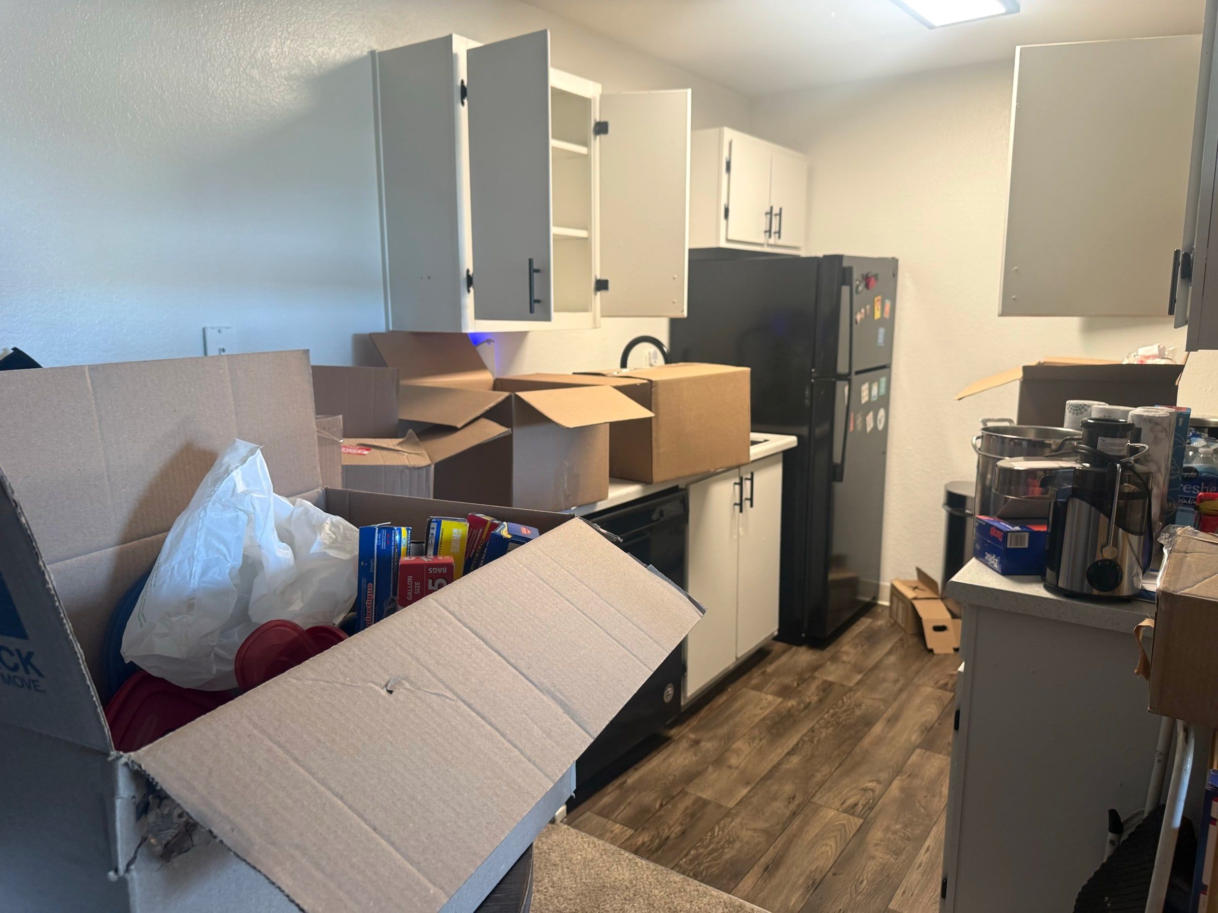 Before: Kitchen with open moving boxes stacked on the counters